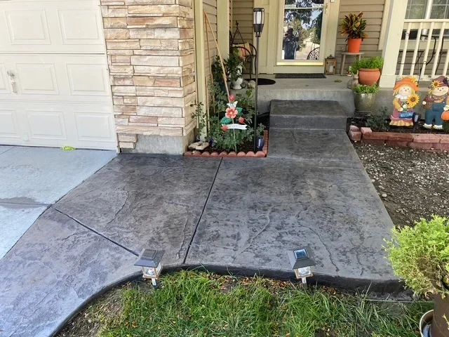 Finished concrete driveway apron with control joints leading to home entry