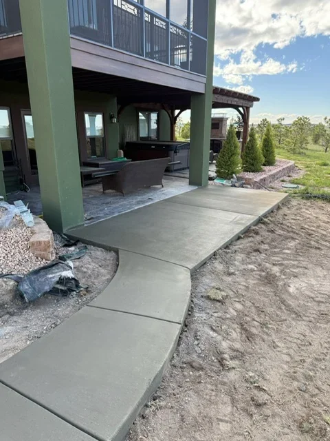 Stepped concrete patio and walkway with pergola and green support columns