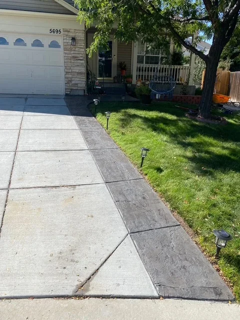 Newly installed concrete driveway and walkway with decorative scoring patterns at residential home